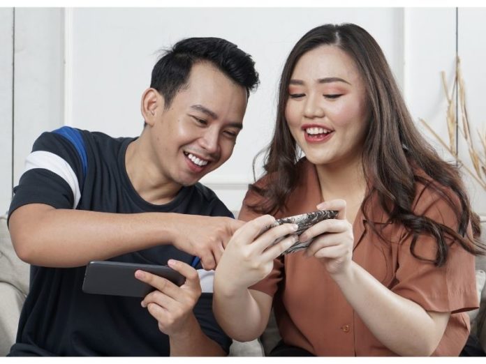 man and woman playing mobile games together