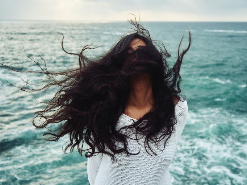 girl at sea with hair blowing in the wind