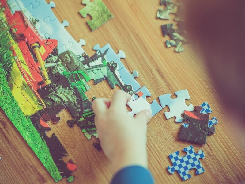 kid solving jigsaw puzzle kids indoor activities