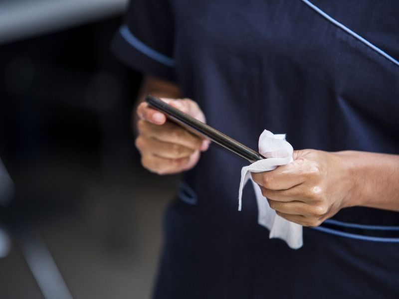 person wiping a smartphone