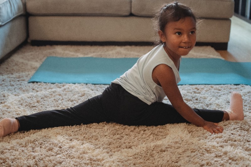 young girl doing split on carpet