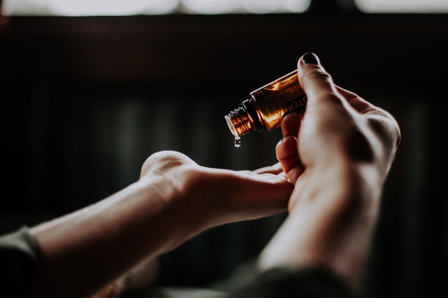 woman pouring oil into palm