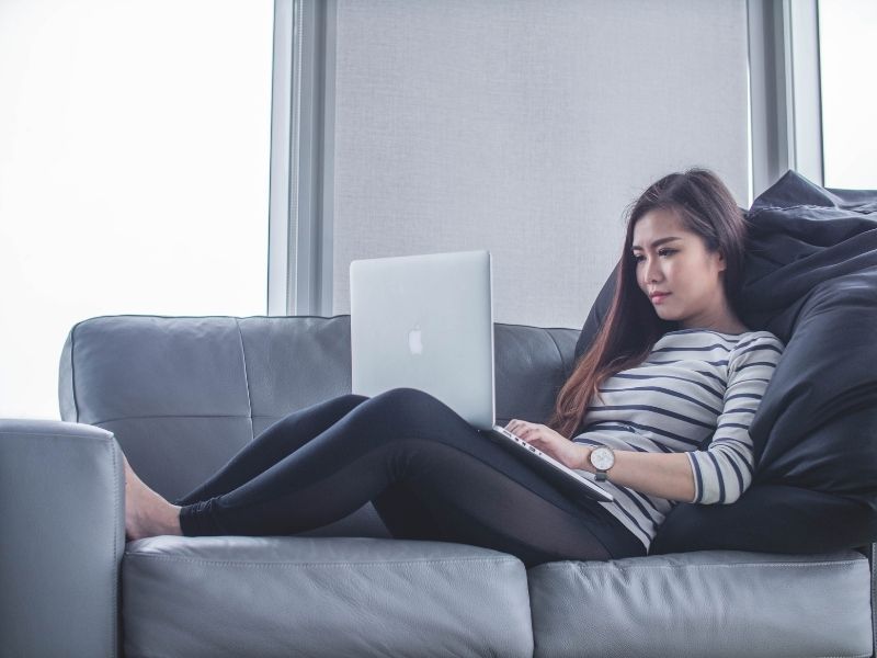 a woman with a laptop on a sofa