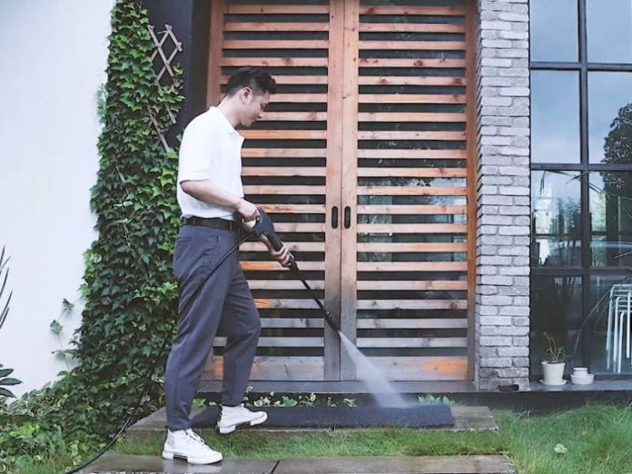 a man washing the floor with a pressure washer