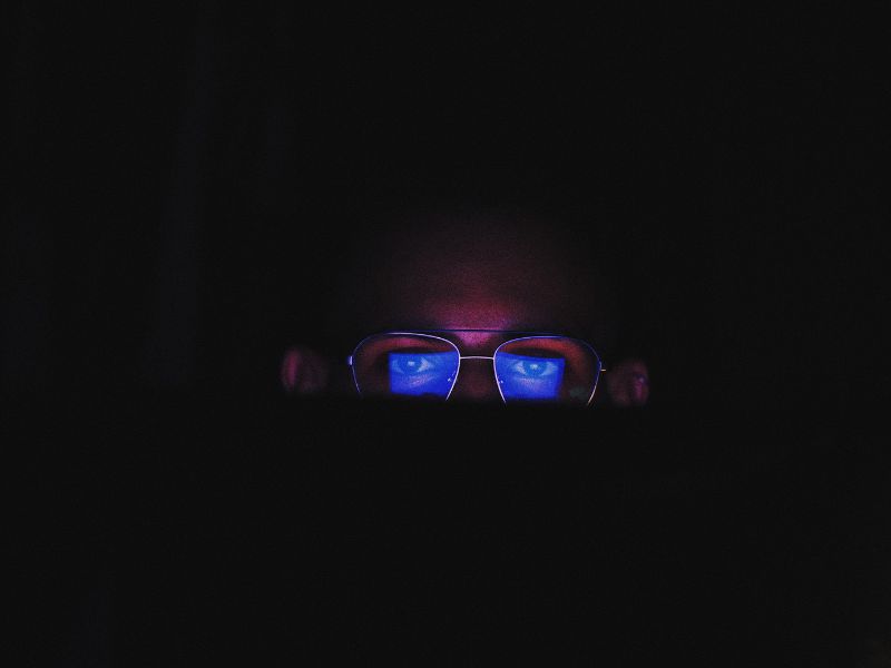 a person looking at a screen in the dark anti blue light glasses