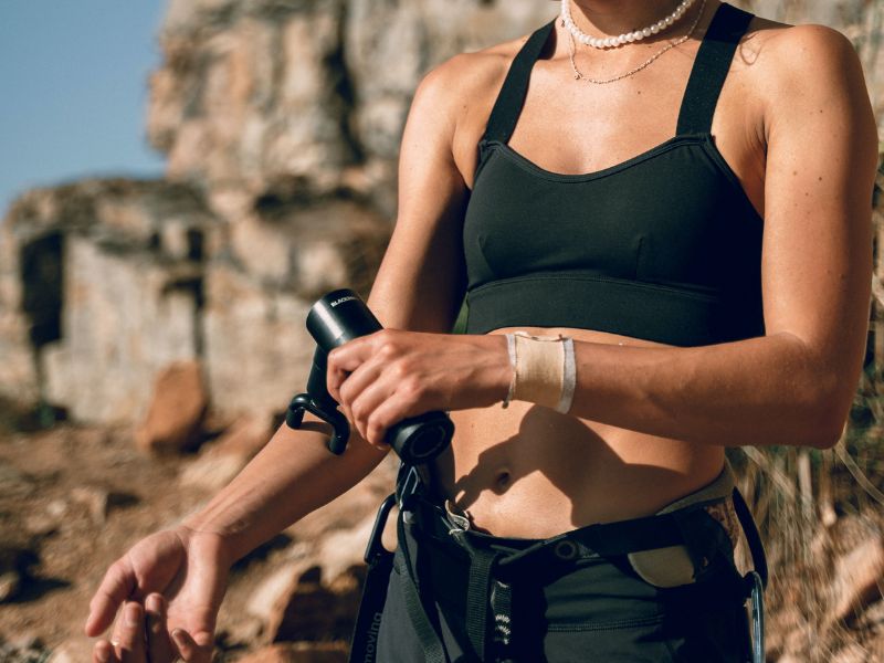 A person using a massage gun on the arm