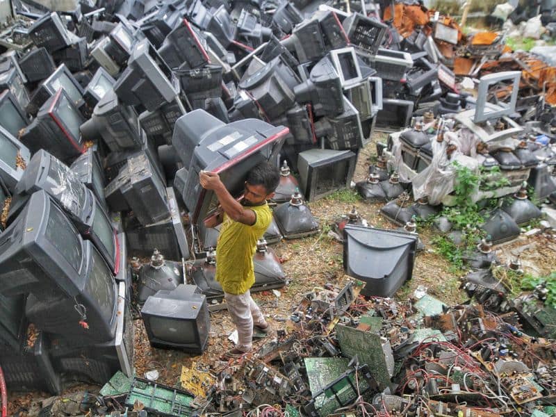 a man carrying a discarded television