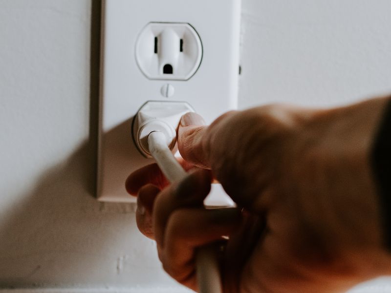 plugging a power cord into a socket