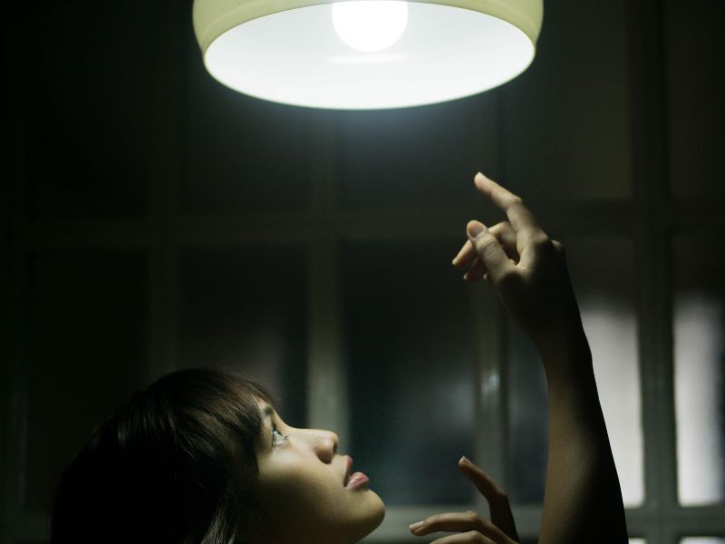 a lady under a ceiling light how to save electricity