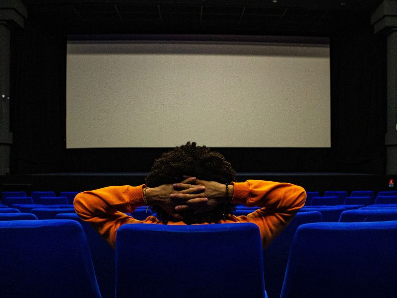 a man watching a movie in a theatre hall