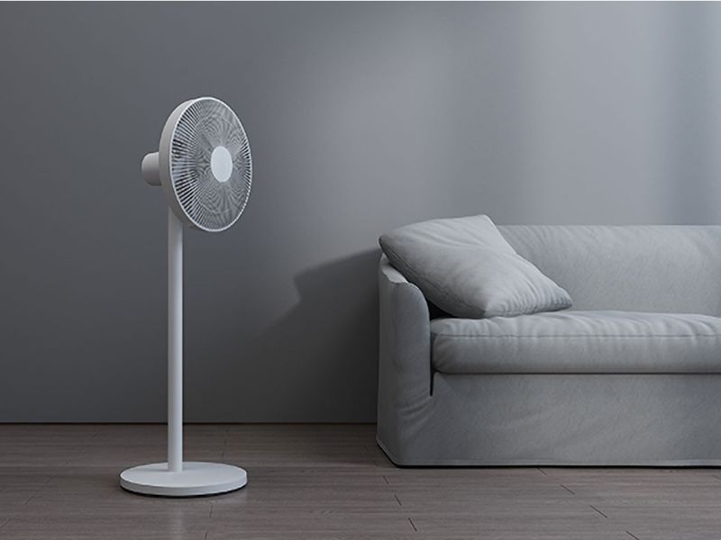 A standing fan beside a sofa
