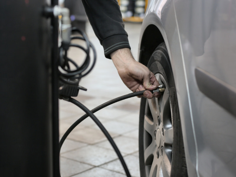 a person filling up a car tyre