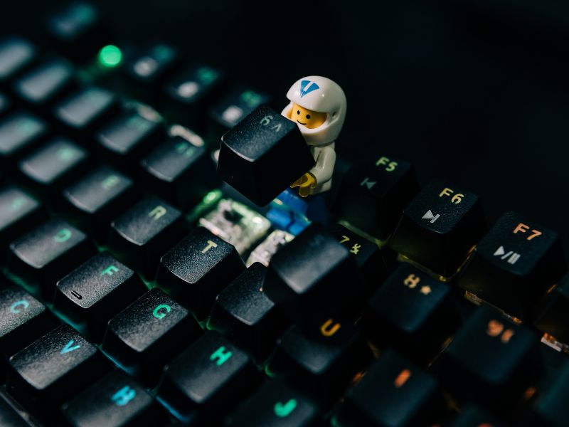 a lego figure holding a keycap