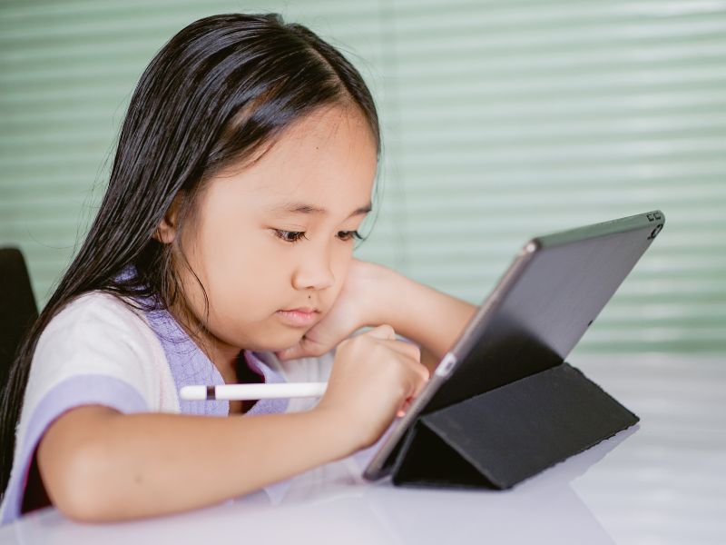 a little girl using a tablet