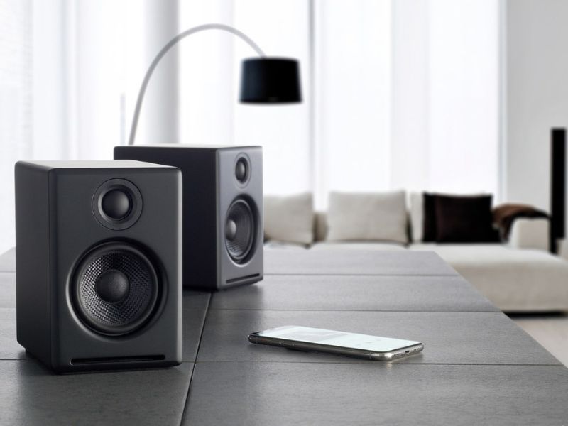 a pair of speakers and a smartphone on a table surface