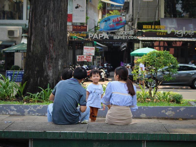 a family with a child sitting by the street father’s day celebration ideas