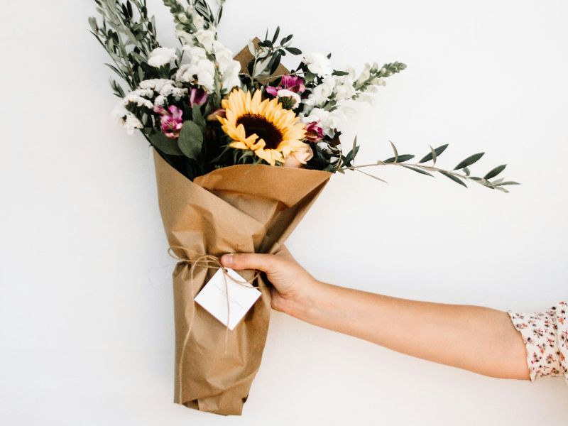 an arm holding a flower bouquet