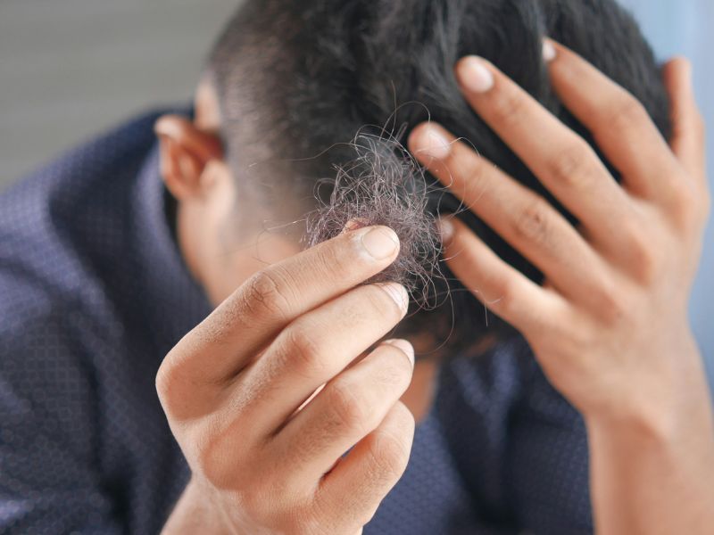 a man holding some fallen hair