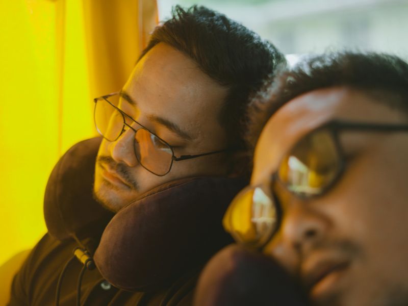 two persons sleeping with neck pillows